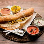 Masala Dosa, un popular plato del sur de la India, servido en un plato blanco, relleno de papas especiadas y cubierto con queso rallado.