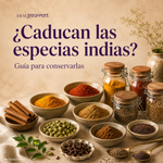 Tarros y cuencos con coloridas especias indias, como cúrcuma, chile en polvo, comino, cardamomo, canela, clavo y hojas de laurel, sobre un fondo beige cálido.