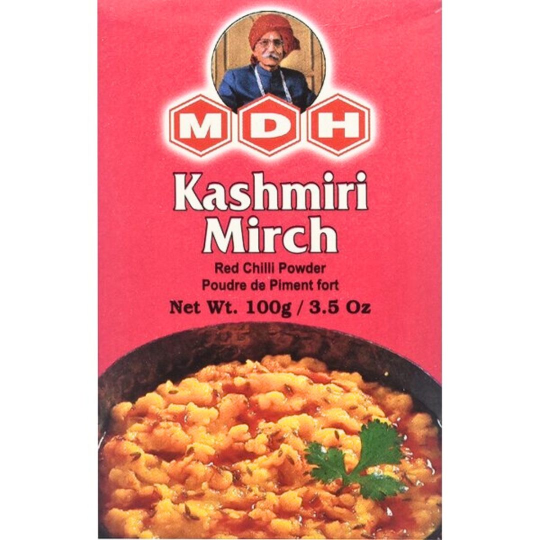 English: "MDH Kashmiri Mirch packaging showcasing its vibrant red chili powder, known for adding a mild heat and intense red color to dishes like dals and curries."
Spanish: "Envase de MDH Kashmiri Mirch que muestra su polvo de chile rojo vibrante, conocido por aportar un suave toque picante y un intenso color rojo a platos como dals y curries."